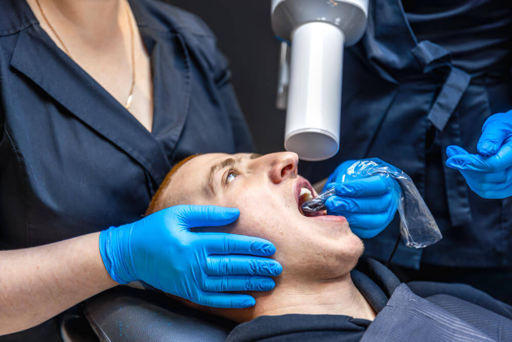 A professional dentist is checking the patient