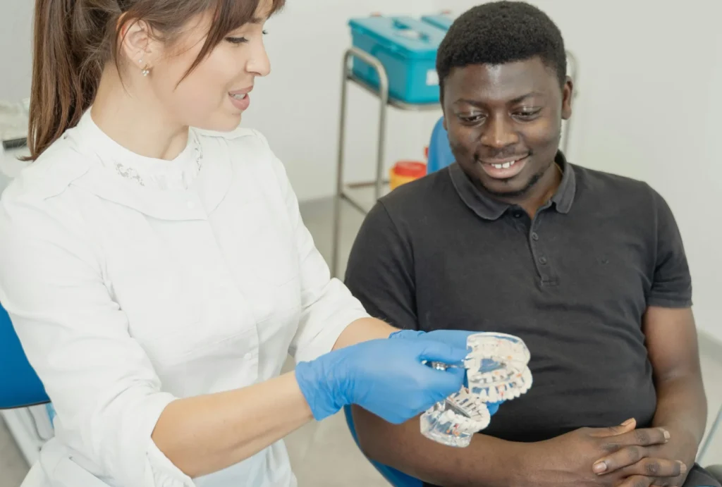 Dentist explaining All on 4 dental implants using a dental model