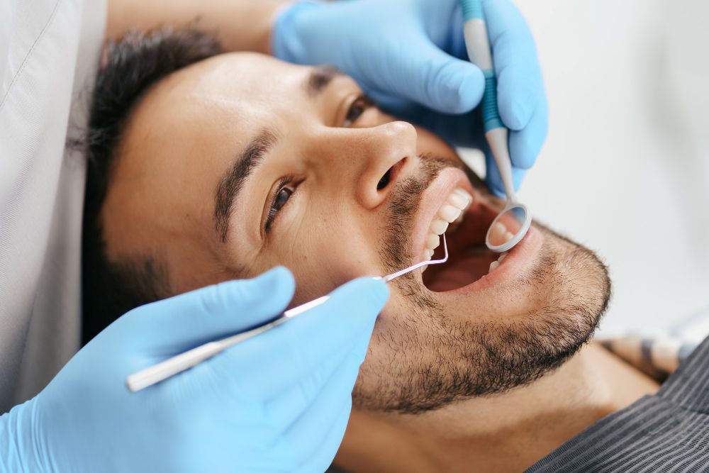 Patient undergoing professional dental treatment by a dentist and assistant in a modern clinic